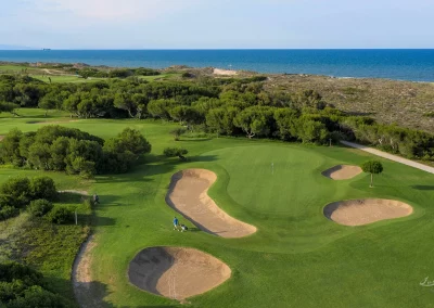 "Bunker de arena blanca estratégicamente situado en el campo de El Saler, capturado con fotografía de alta resolución para arquitectura deportiva."