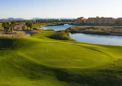 Lago estratégico reflejando el green en Saurines Golf Murcia al atardecer